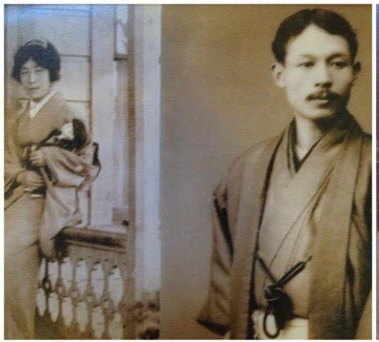 Photo of a Japanese woman holding a teddy bear and a Japanese man in traditional robes
